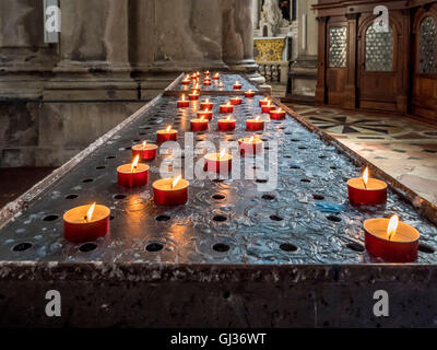 La prière ou bougies votives brûlant à l'intérieur de l'église Santa Maria della Salute, Venise, Italie. Banque D'Images