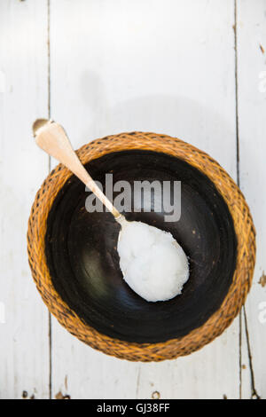 Vue de dessus de cuillerée de l'huile de coco sur bol froid Banque D'Images