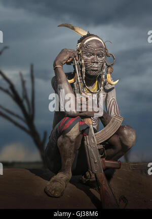 Jeune guerrier de la tribu Mursi avec fusil Kalachnikov, vallée de l'Omo, Ethiopie Banque D'Images