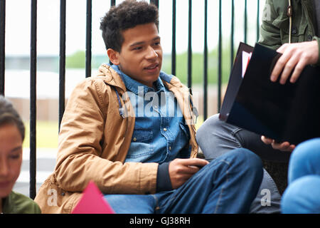Les étudiants du collège des jeunes adultes sur le chat et la révision sur le campus Banque D'Images