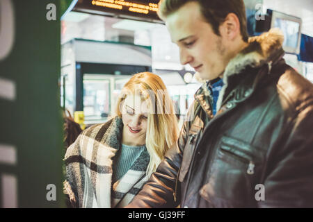 Jeune couple qui achète des billets de train ticket machine Banque D'Images