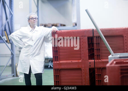 Factory worker wearing ensemble et filet à cheveux looking at camera Banque D'Images