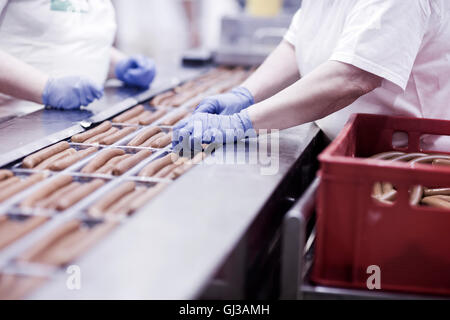 Les travailleurs d'usine sur la ligne de production de saucisses de tofu Banque D'Images