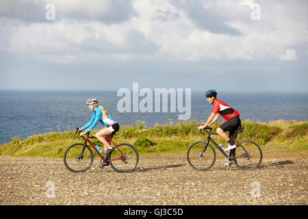 Cyclists riding sur gravier surplombant Ocean Banque D'Images