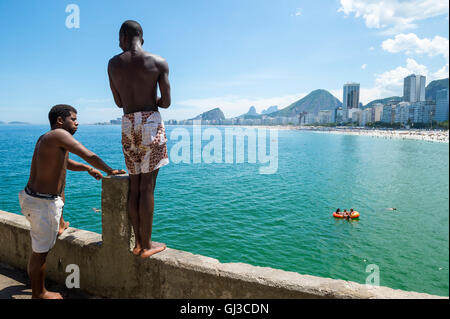 RIO DE JANEIRO - le 27 février 2016 : les jeunes Brésiliens se rassemblent pour plonger à partir de la corniche à Copacabana, à l'extrémité de la plage de Copacabana. Banque D'Images