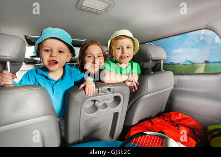 Maman heureuse d'avoir du plaisir avec ses fils sitting in car Banque D'Images