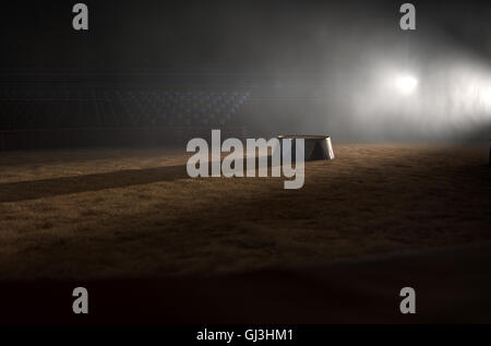 Un rendu 3D d'une scène de cirque classique et un podium ringmasters vide par rétro-projecteurs dramatiques sur un arrière-plan foncé moody Banque D'Images