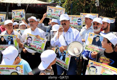 Jérusalem, Jérusalem, territoire palestinien. 12Th Aug 2016. Des manifestants palestiniens tenir affiches contre la détention administrative et à l'appui du prisonnier palestinien Bilal Kayed (portrait), qui avait jeûné pendant près de deux mois au cours de sa détention sans procès, comme ils démontrent à l'extérieur de la Croix-Rouge à Jérusalem est le 12 août 2016. Credit : ZUMA Press, Inc./Alamy Live News Banque D'Images