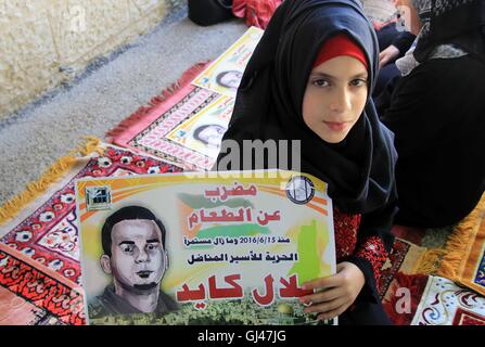 Jérusalem, Jérusalem, territoire palestinien. 12Th Aug 2016. Des manifestants palestiniens tenir affiches contre la détention administrative et à l'appui du prisonnier palestinien Bilal Kayed (portrait), qui avait jeûné pendant près de deux mois au cours de sa détention sans procès, comme ils démontrent à l'extérieur de la Croix-Rouge à Jérusalem est le 12 août 2016. Credit : ZUMA Press, Inc./Alamy Live News Banque D'Images