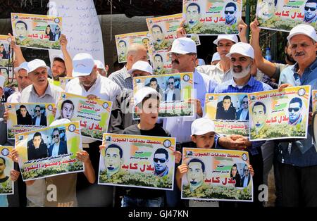 Jérusalem, Jérusalem, territoire palestinien. 12Th Aug 2016. Des manifestants palestiniens tenir affiches contre la détention administrative et à l'appui du prisonnier palestinien Bilal Kayed (portrait), qui avait jeûné pendant près de deux mois au cours de sa détention sans procès, comme ils démontrent à l'extérieur de la Croix-Rouge à Jérusalem est le 12 août 2016. Credit : ZUMA Press, Inc./Alamy Live News Banque D'Images