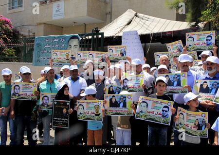 Jérusalem, Jérusalem, territoire palestinien. 12Th Aug 2016. Des manifestants palestiniens tenir affiches contre la détention administrative et à l'appui du prisonnier palestinien Bilal Kayed (portrait), qui avait jeûné pendant près de deux mois au cours de sa détention sans procès, comme ils démontrent à l'extérieur de la Croix-Rouge à Jérusalem est le 12 août 2016. Credit : ZUMA Press, Inc./Alamy Live News Banque D'Images