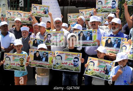 Jérusalem, Jérusalem, territoire palestinien. 12Th Aug 2016. Des manifestants palestiniens tenir affiches contre la détention administrative et à l'appui du prisonnier palestinien Bilal Kayed (portrait), qui avait jeûné pendant près de deux mois au cours de sa détention sans procès, comme ils démontrent à l'extérieur de la Croix-Rouge à Jérusalem est le 12 août 2016. Credit : ZUMA Press, Inc./Alamy Live News Banque D'Images