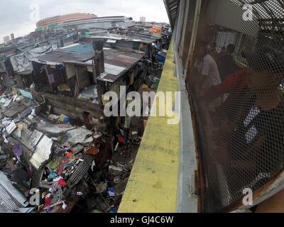 Quezon City, Philippines. 13e Août 2016. Les sauveteurs tentent de sauver un homme coincé sous les rocailles d'un mur de béton à un bidonville de Manille, Philippines, le 13 août 2016. Le mur de béton s'est effondré le taudis où quatre personnes ont été bloqués en raison de la persistance de fortes pluies apportées par la mousson du sud-ouest. Deux personnes sont mortes et 15 personnes ont été blessées dans l'accident, selon la manille de la réduction des risques de catastrophe et le Bureau de gestion (MDRRMO). Credit : Rouelle Umali/Xinhua/Alamy Live News Banque D'Images