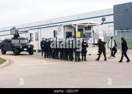 La police anti-émeute se déplacent dans d'arrêter les manifestants à l'extérieur d'un centre de distribution Walmart de la région de Chicago. Banque D'Images