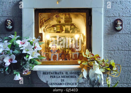 Un petit sanctuaire dans une ruelle dans le centre historique de Naples. Il représente le Christ en croix, saint Pie et les photos des morts napolitains du quartier. Banque D'Images