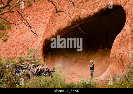 Un ranger avec un groupe de touristes sur le Mala à pied à Uluru dans le Parc National d'Uluru-Kata Tjuta. Banque D'Images