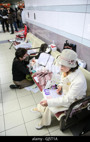 À l'intérieur de l'énorme stand punters contrôle de la forme des chevaux de race 11, la grande course du jour l'American Jockey Club Cup avec de Banque D'Images