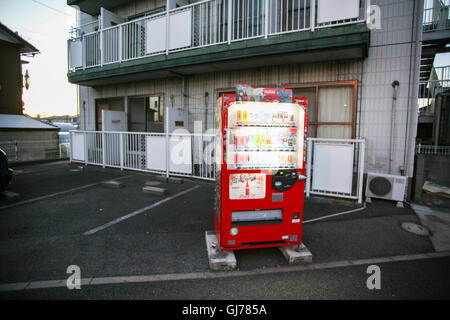 En face de cet appartement bulding un seul distributeur automatique qui s'illumine au coucher du soleil, ici dans Nakayama, Chiba, banlieue de Tokyo. Banque D'Images