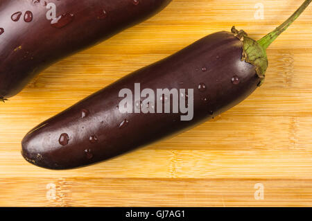 Still Life - deux délicieux et sains aubergines violettes sur planche de bois Banque D'Images