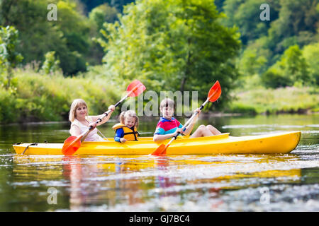 Famille heureuse avec deux enfants bénéficiant de belle rivière en kayak. Maman avec petite fille et garçon adolescent kayak Banque D'Images