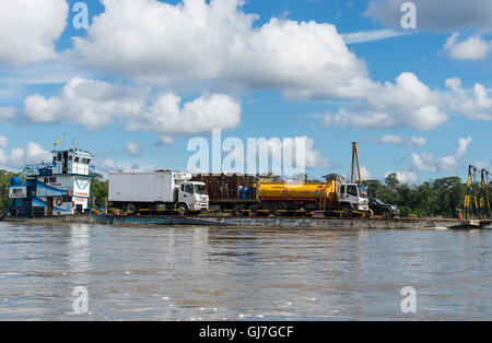 Les poids lourds sont chargés sur barge et transportés le long du Rio Napo dans les Amazones. L'Équateur, en Amérique du Sud. Banque D'Images