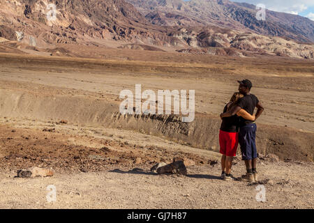 Couple Interracial profitant de la vue sur le collines volcaniques et sédimentaires près de la palette d'artiste, Death Valley National Park, CA Banque D'Images