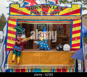 Mr Punch semble loin de la perforeuse et Judy marionnette stand avec un bâton dans sa main et Joey le clown derrière Banque D'Images