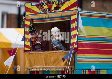 Mr Punch avec Judy et bébé en face d'un Punch & Judy marionnette stand. L'angle inhabituel et peu de profondeur de champ 2 créer une image dynamique Banque D'Images