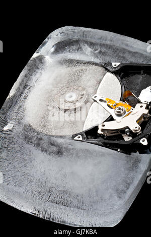 Disque dur congelé dans un bloc de glace sur un fond noir Banque D'Images