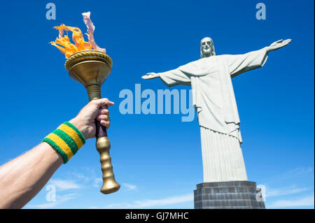 RIO DE JANEIRO - le 21 mars 2016 : porteur de torche en face de la statue du Christ Rédempteur à Corcovado. Banque D'Images