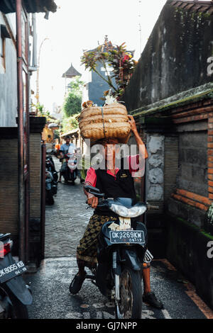 Ubud, Indonésie - 28 Février 2016 : l'homme balinais portant des paniers d'offrandes sur sa tête, Ubud, Bali, Indonésie. Banque D'Images