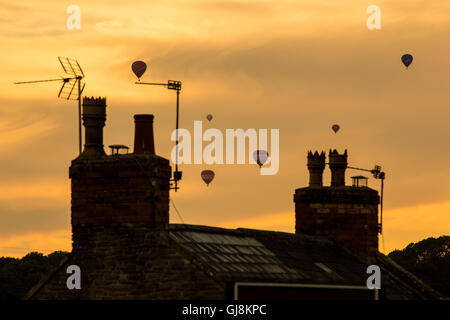 Bristol, Royaume-Uni. 13e Août 2016. L'ascension de la Bristol Balloon Fiesta Festival arrive enfin en cours après des retards en raison des vents violents depuis le jeudi. Un magnifique coucher de soleil a agi comme une toile de fond à plusieurs ballons qui a pris au ciel après les organisateurs du festival ont donné le feu vert pour décoller. Les ballons dérivaient sur la ville de Bristol vers les hameaux de Bitton et Keynsham avant de toucher par champs aléatoires et de parc de nombreux kilomètres de l'Ashton Court site du festival. Credit : Wayne Farrell/Alamy Live News Banque D'Images