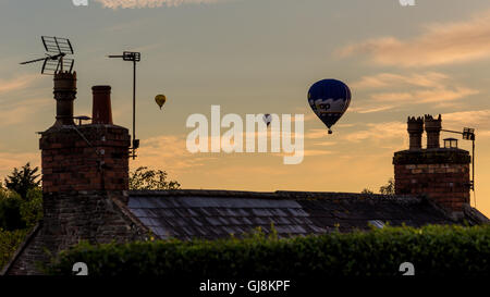 Bristol, Royaume-Uni. 13e Août 2016. L'ascension de la Bristol Balloon Fiesta Festival arrive enfin en cours après des retards en raison des vents violents depuis le jeudi. Un magnifique coucher de soleil a agi comme une toile de fond à plusieurs ballons qui a pris au ciel après les organisateurs du festival ont donné le feu vert pour décoller. Les ballons dérivaient sur la ville de Bristol vers les hameaux de Bitton et Keynsham avant de toucher par champs aléatoires et de parc de nombreux kilomètres de l'Ashton Court site du festival. Credit : Wayne Farrell/Alamy Live News Banque D'Images