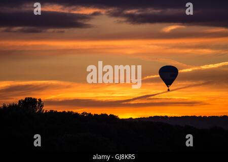 Bristol, Royaume-Uni. 13e Août 2016. L'ascension de la Bristol Balloon Fiesta Festival arrive enfin en cours après des retards en raison des vents violents depuis le jeudi. Un magnifique coucher de soleil a agi comme une toile de fond à plusieurs ballons qui a pris au ciel après les organisateurs du festival ont donné le feu vert pour décoller. Les ballons dérivaient sur la ville de Bristol vers les hameaux de Bitton et Keynsham avant de toucher par champs aléatoires et de parc de nombreux kilomètres de l'Ashton Court site du festival. Credit : Wayne Farrell/Alamy Live News Banque D'Images