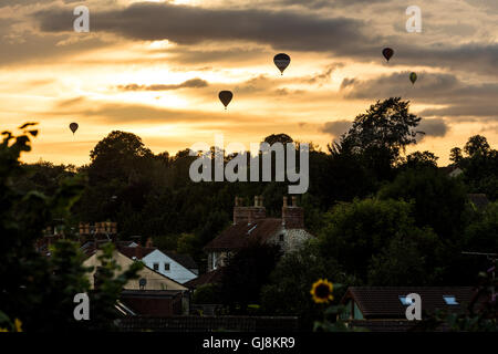 Bristol, Royaume-Uni. 13e Août 2016. L'ascension de la Bristol Balloon Fiesta Festival arrive enfin en cours après des retards en raison des vents violents depuis le jeudi. Un magnifique coucher de soleil a agi comme une toile de fond à plusieurs ballons qui a pris au ciel après les organisateurs du festival ont donné le feu vert pour décoller. Les ballons dérivaient sur la ville de Bristol vers les hameaux de Bitton et Keynsham avant de toucher par champs aléatoires et de parc de nombreux kilomètres de l'Ashton Court site du festival. Credit : Wayne Farrell/Alamy Live News Banque D'Images