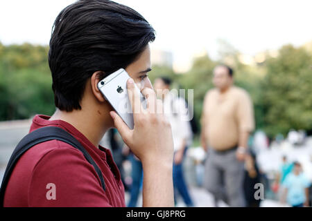 Téhéran, Iran. 13e Août 2016. Un jeune homme à l'aide d'un iPhone à Téhéran, Iran, 13 août 2016. Les iPhones sont très populaires en Iran, mais disponible uniquement en raison de l'illégalement les sanctions américaines. Le gouvernement iranien prévoit de fermer le marché illégal et l'importation de la cuisine via des entreprises sélectionnées. Néanmoins, US-marchandises américaines ne sont toujours pas autorisés à être importés en Iran en raison des sanctions. PHOTO : FARSHID M. BINA/dpa/Alamy Live News Banque D'Images