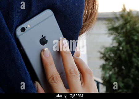 Téhéran, Iran. 13e Août 2016. Une jeune femme à l'aide d'un iPhone à Téhéran, Iran, 13 août 2016. Les iPhones sont très populaires en Iran, mais disponible uniquement en raison de l'illégalement les sanctions américaines. Le gouvernement iranien prévoit de fermer le marché illégal et l'importation de la cuisine via des entreprises sélectionnées. Néanmoins, US-marchandises américaines ne sont toujours pas autorisés à être importés en Iran en raison des sanctions. PHOTO : FARSHID M. BINA/dpa/Alamy Live News Banque D'Images