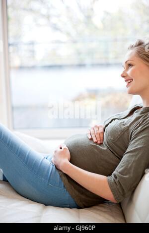 Parution du modèle. Femme enceinte de toucher son ventre. Banque D'Images