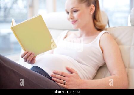 Parution du modèle. Pregnant woman reading book. Banque D'Images