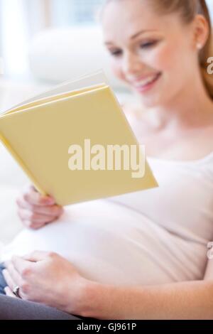 Parution du modèle. Pregnant woman reading book. Banque D'Images