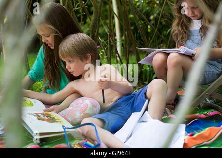 Parution de la propriété. Parution du modèle. Enfants jouant dans un repaire dans le jardin. Banque D'Images