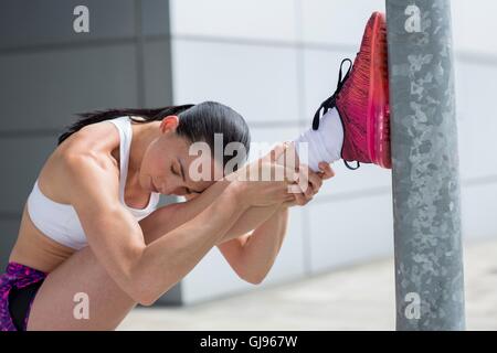 Parution du modèle. Young woman stretching des muscles des jambes. Banque D'Images