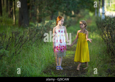 Deux jeunes filles parler dans le parc main dans la main. Banque D'Images