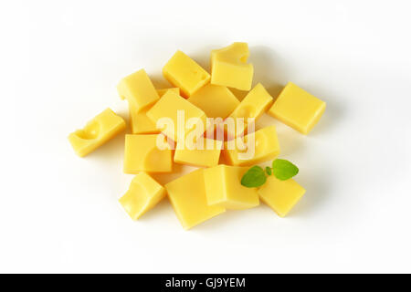 Poignée de cubes de fromage sur fond blanc Banque D'Images