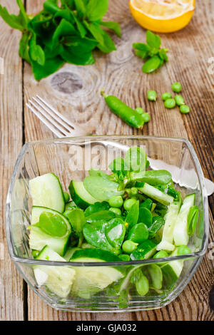 Avec salade de concombre, le pourpier et les pois verts sur les disques sombres Banque D'Images