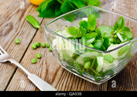 Avec salade de concombre, le pourpier et les pois verts sur les disques sombres Banque D'Images