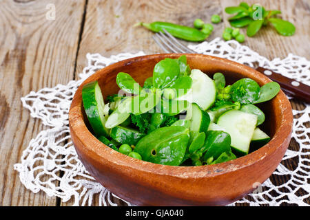 Avec salade de concombre, le pourpier et les pois verts sur les disques sombres Banque D'Images