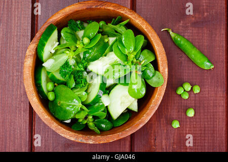 Avec salade de concombre, le pourpier et les pois verts sur les disques sombres Banque D'Images