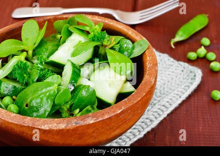 Avec salade de concombre, le pourpier et les pois verts sur les disques sombres Banque D'Images