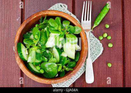 Avec salade de concombre, le pourpier et les pois verts sur les disques sombres Banque D'Images